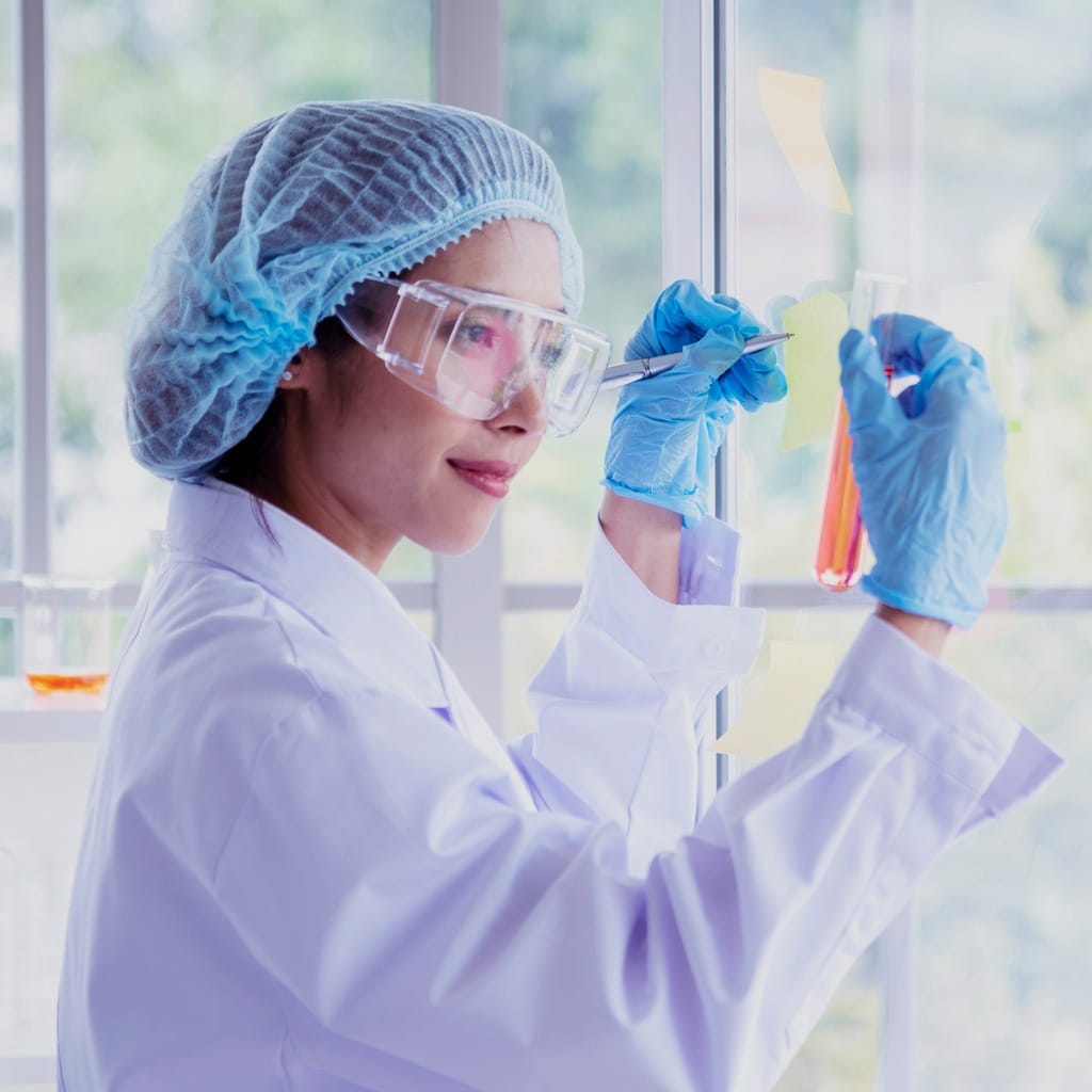 Ethide Labs. News and articles about laboratory testing. Woman scientist handling a test tube analysis for testing devices. Chemistry laboratory testing