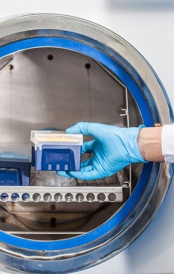 Sterility services. Sicentist sterilizing laboratory material in autoclave