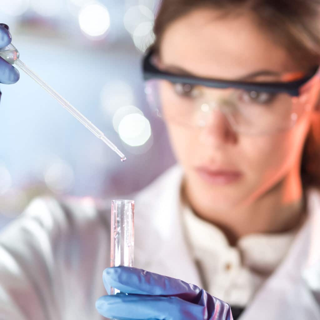 Endotoxin Limits And Calculations For Medical Devices And Combination Products. Woman scientist dropping fluids inside a test tube. New and articles. Blog. Info testing labs
